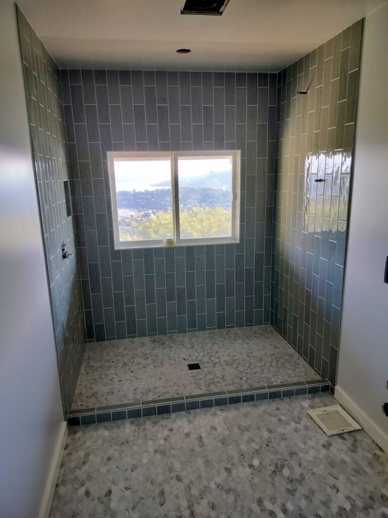 After: Sugarloaf hall bath with vertical stacked tile and linear drain