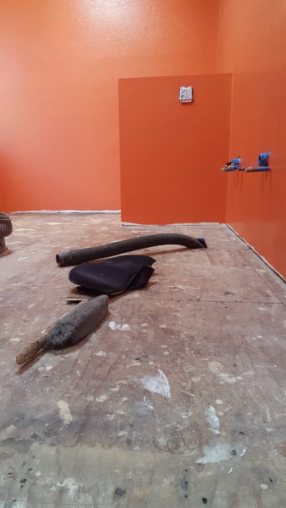 Mill Valley bathroom before tile installation, showing exposed plywood subfloor, plumbing connections and preparation tools.